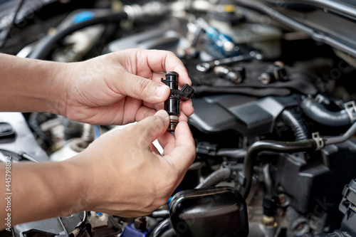 Technician Removing the gasoline injector part in engine room check dust and test pressure in process maintenance concept