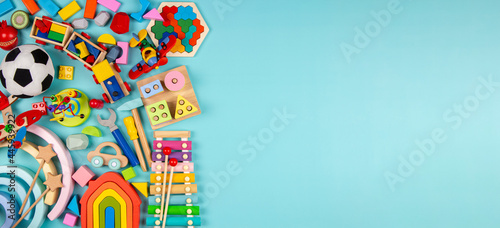 Baby kids toys on light blue background. Colorful educational wooden, plastic, fluffy and musical toys. Top view, flat lay