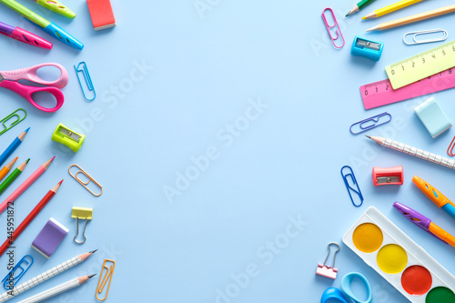 Flat lay colorful school supplies on blue background. Back to school concept. Top view, overhead.