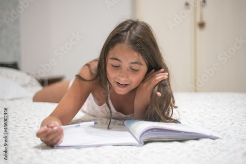 Happy young girl making holiday school homework.