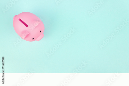 Pink piggy bank on blue background. Finance, saving money concept, financial planning of personal finances and being thrifty.