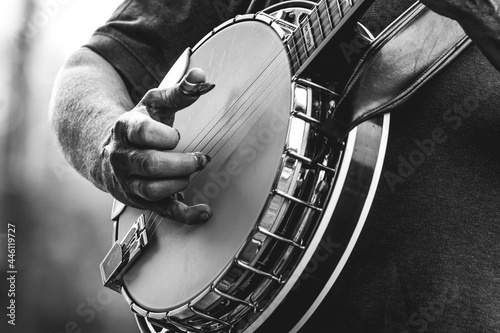 mature, older man, male playing five string banjo outside in monochrome black and white close-up of hand and fingers bluegrass music