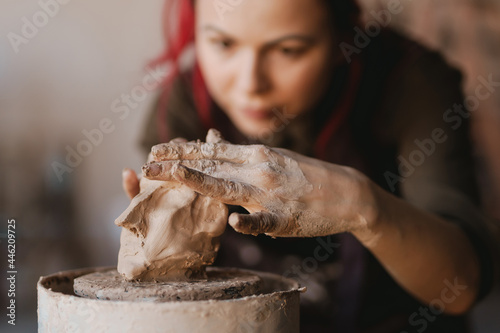 Young woman sculptor artist creating a bust sculpture