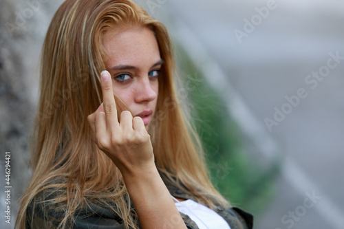 Rude vindictive young woman giving the middle finger