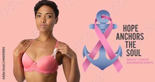 Composition of pink ribbon anchor logo and breast cancer text, with smiling woman in pink bra