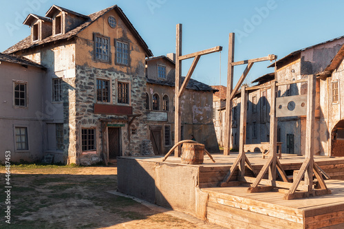 A yard and gallows in front of 18th century houses against a sky in the piligrim porto by spring day