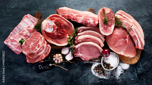 Different types of raw meat on black background