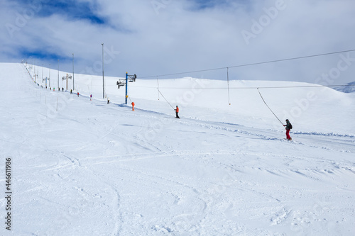 snowboarders and mountain-skiers rising the mountain in russian polar ski resort