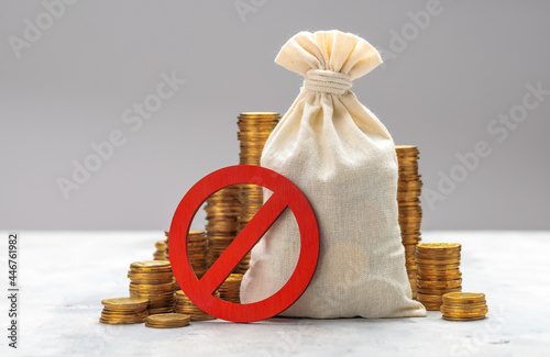 Prohibition sign. Money bag and stacks of coins on a gray background. No symbol and money