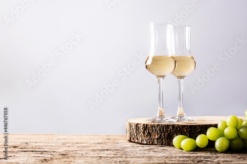 Italian golden grappa drink on wooden background. Copy space