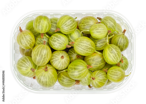Green gooseberries in a wooden bowl. Fresh and ripe berries, fruits of Ribes, also known as European gooseberry, with sourish sweet taste. Close-up, from above, isolated over white, macro food photo.
