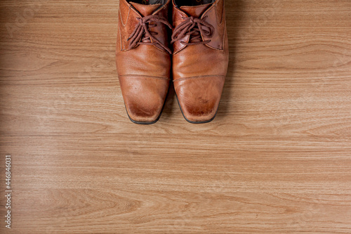 Men's leather shoes on a wooden background. Flat lay, top view. Fashion concept.