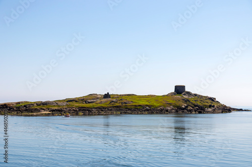 Dalkey Island with church ruin and martello tower on Summer day. Irish Sea. coast, Dublin, Ireland. People in ferry boat travel on day trip