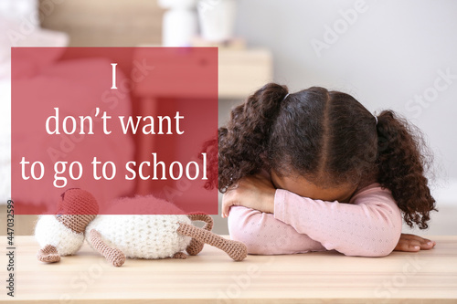 Sad African-American girl refusing to go to school at home