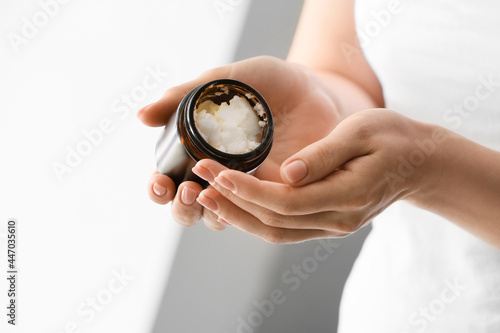 Woman holding jar with shea butter, closeup