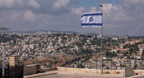 The observation point from the Mount of Olives onto the neighborhood of East Jerusalem. The Israeli flag waving in the wind on the foreground.