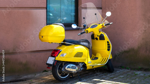 Żółty skuter, motor na tle ściany