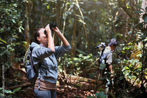 Woman tourist watching birds in jungle in Khao Yai National Park, Thailand