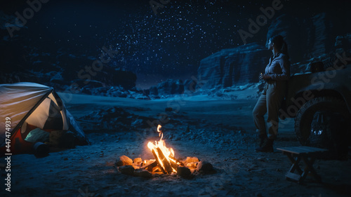 Female Traveler Watching Night Sky while Camping in the Canyon by Campfire. Amazing Campsite view of Milky Way Stars with Traveling Woman Adventurer on Inspirational Nature Loving Journey