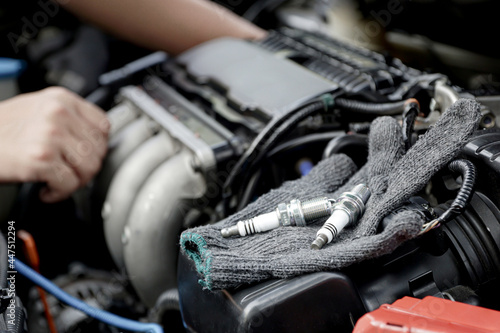 Cloth gloves and car spark plug on engine,Technician service and repairing service concept of car