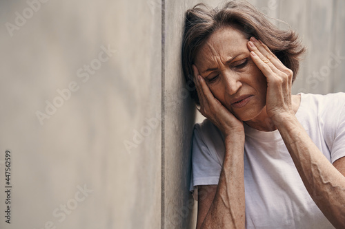 Seniour woman suffering from headache in open air