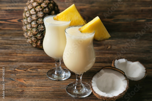 Glasses with tasty Pina Colada cocktail on wooden background