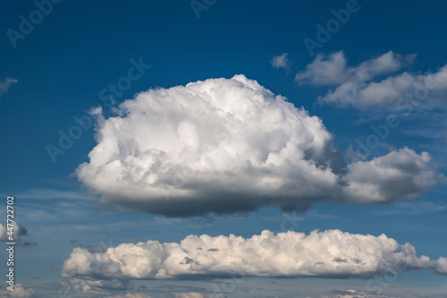 Blue sky background with big white tiny stratus cirrus striped clouds