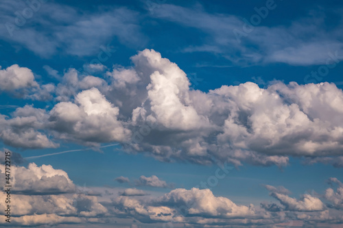 Blue sky background with big white tiny stratus cirrus striped clouds