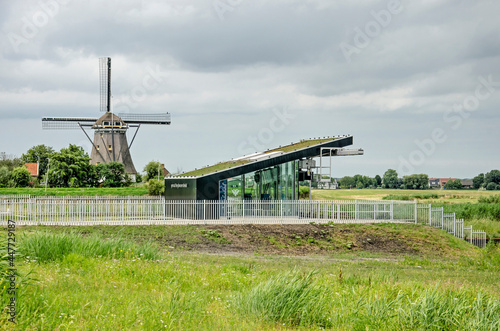 Lansingerland, The Netherlands, July 27, 2021: windmill De Valk and the modern pumping station that has taken over the dask of draining the adjacent polder