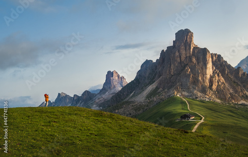 A photographer using a camera making a Beautiful early morning Dolomites Alps mountain landscape photo. Giau Pass or Passo di Giau - 2236m mountain pass in the province of Belluno in Italy.