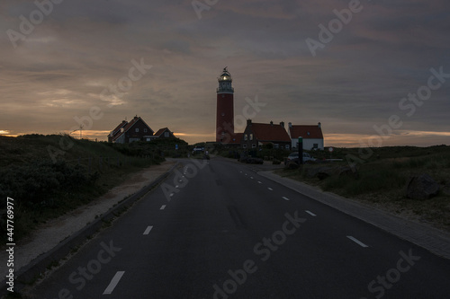 red lighthouse with some houses on the Waddenisle of texel