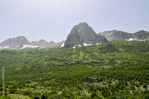 Blick auf das Gebirge mit schneebedeckten Berge im Nationalpark Theth in Albanien, im Sommer bei blauem Himmel