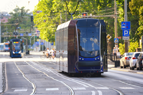 Tramwaj jedzie przez wrocław po torach z wycieczką.