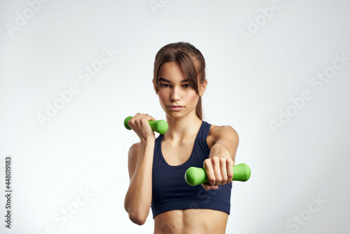 sportive woman with dumbbells in hands pumped up press fitness exercise gym