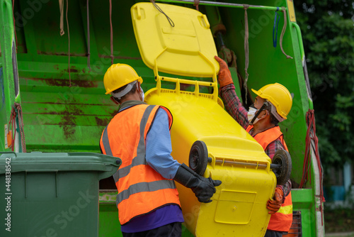 Garbage collectors teamwork and wear uniforms.