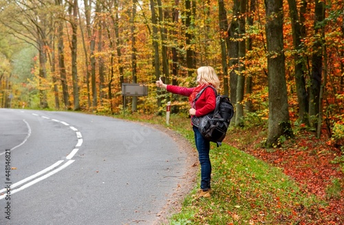A young girl stands on the road and tries to stop the car