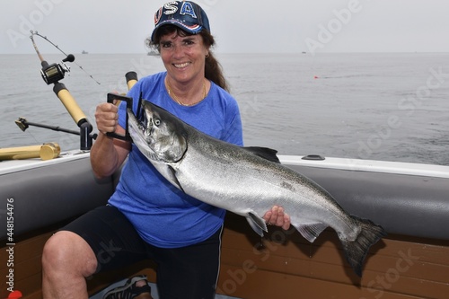 A woman with a Chinook salmon she caught 