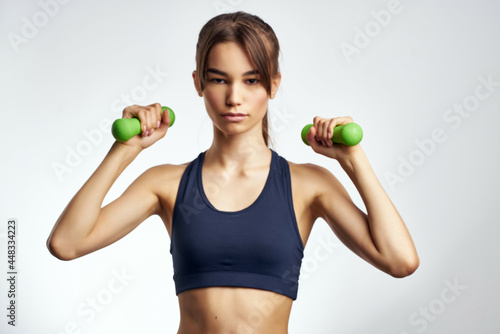 pretty woman with dumbbells in hands exercise slim workout figure