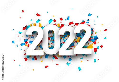 2022 white sign over colourful confetti.