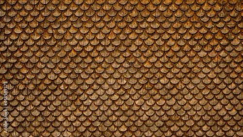 Traditional ecological consistent cladding of a wall with brown wooden larch fish scales, wood shingles, clapboard, clapboard texture background 3D scindula in Voralberg