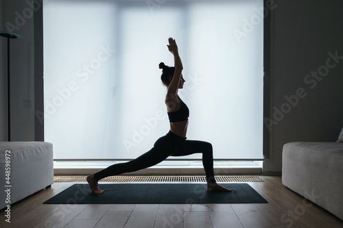 Woman performming high crescent lunge position at home