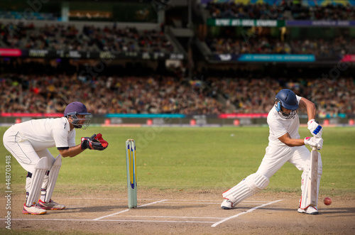 Cricketer batsman hitting a shot during a match on the pitch