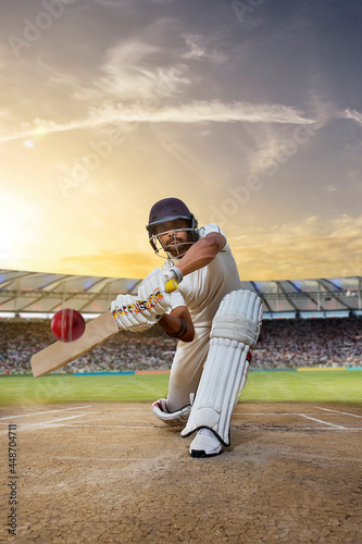 Cricketer batsman hitting a shot during a match on the pitch