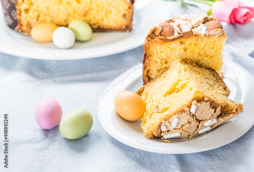 Piece of traditional italian Easter cake Colomba and Easter marzipan eggs in pastel colors, close up