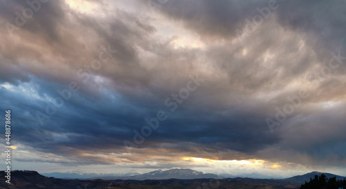 Grandi nuvole rosa e grigie con i monti le colline e la valli degli Appennini all’orizzonte