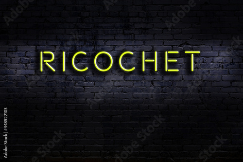 Neon sign. Word ricochet against brick wall. Night view