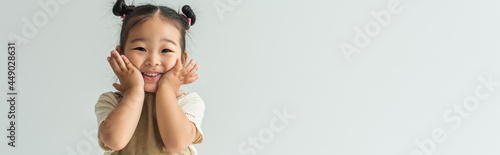 happy asian toddler girl smiling isolated on grey, banner