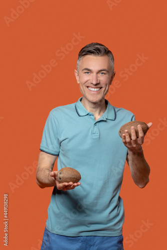 Man holding out small coconuts in his palms