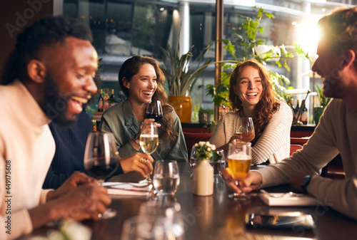 Friends laughing with drinks in bar