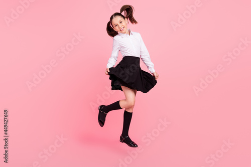 Full size photo of young happy positive happy girl cute smile jump up pupil isolated on pink color background